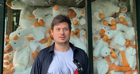 Konrad in front of a window full of duck plush toys
