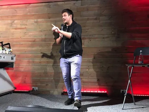 Konrad at the microphone on a red-lit stage